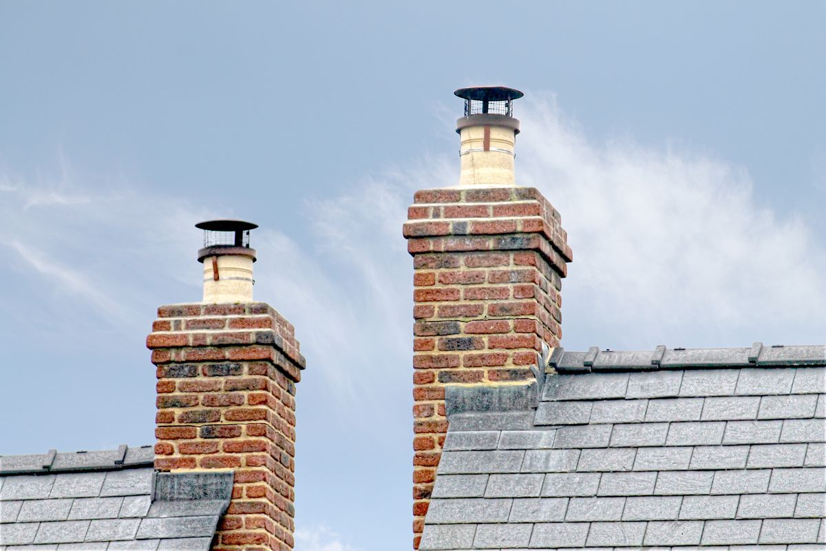 Close-up of traditional brick chimneys on a slate roof