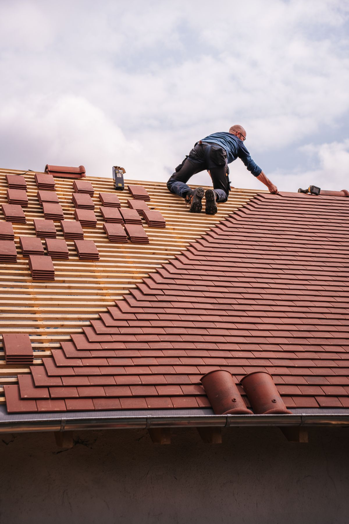 Roofer installing shingles on a residential roof