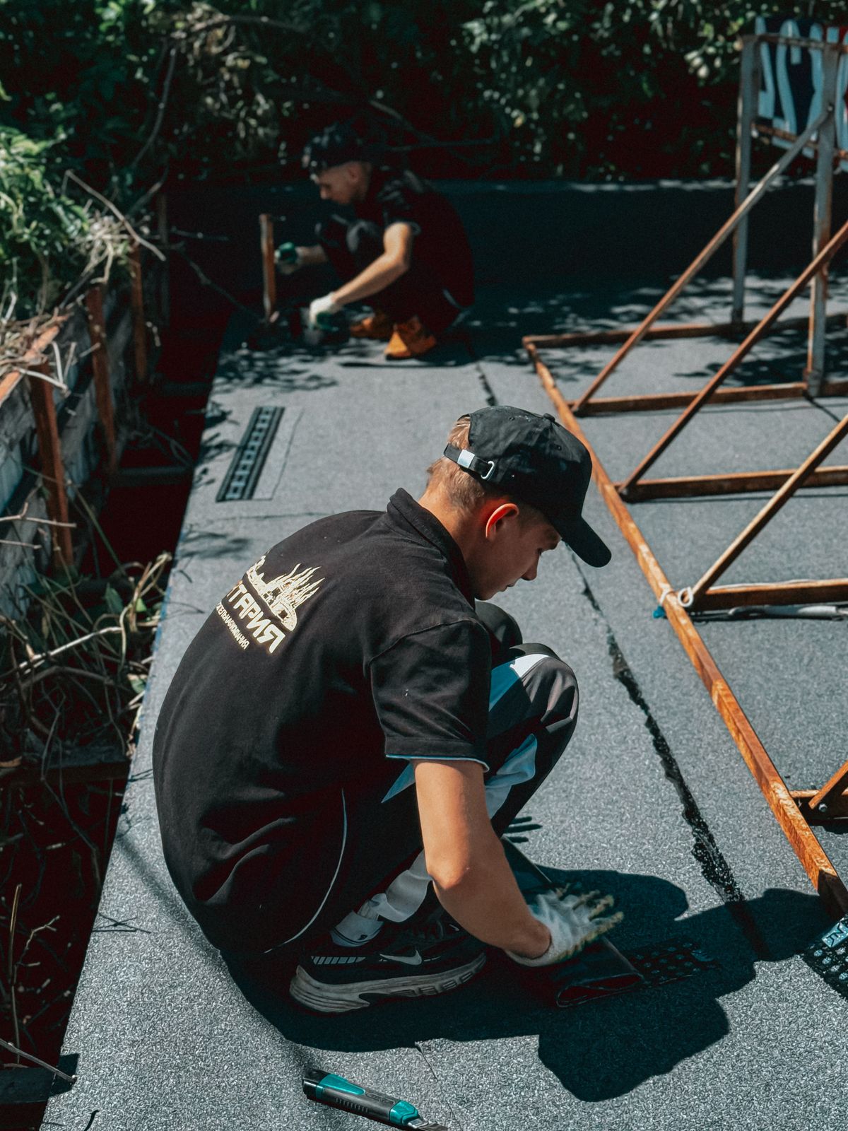 Workers applying a waterproofing membrane on a rooftop