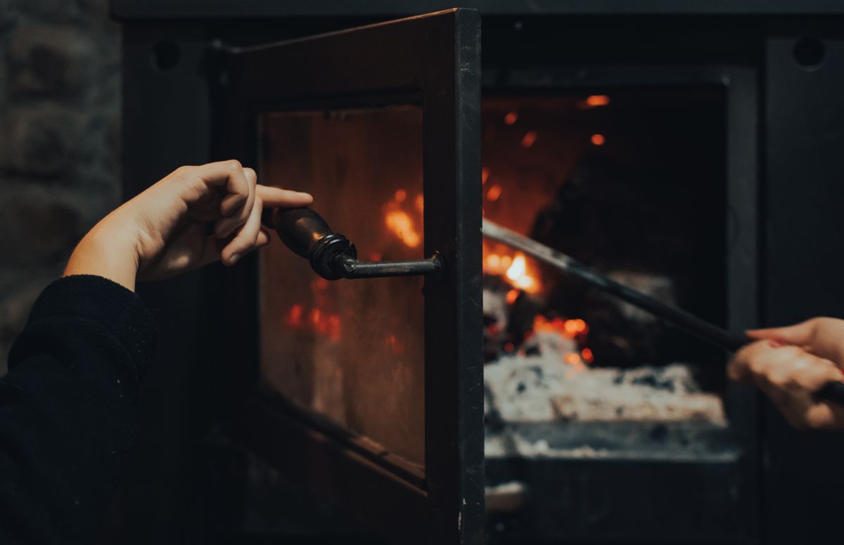 Hands opening and checking a home fireplace