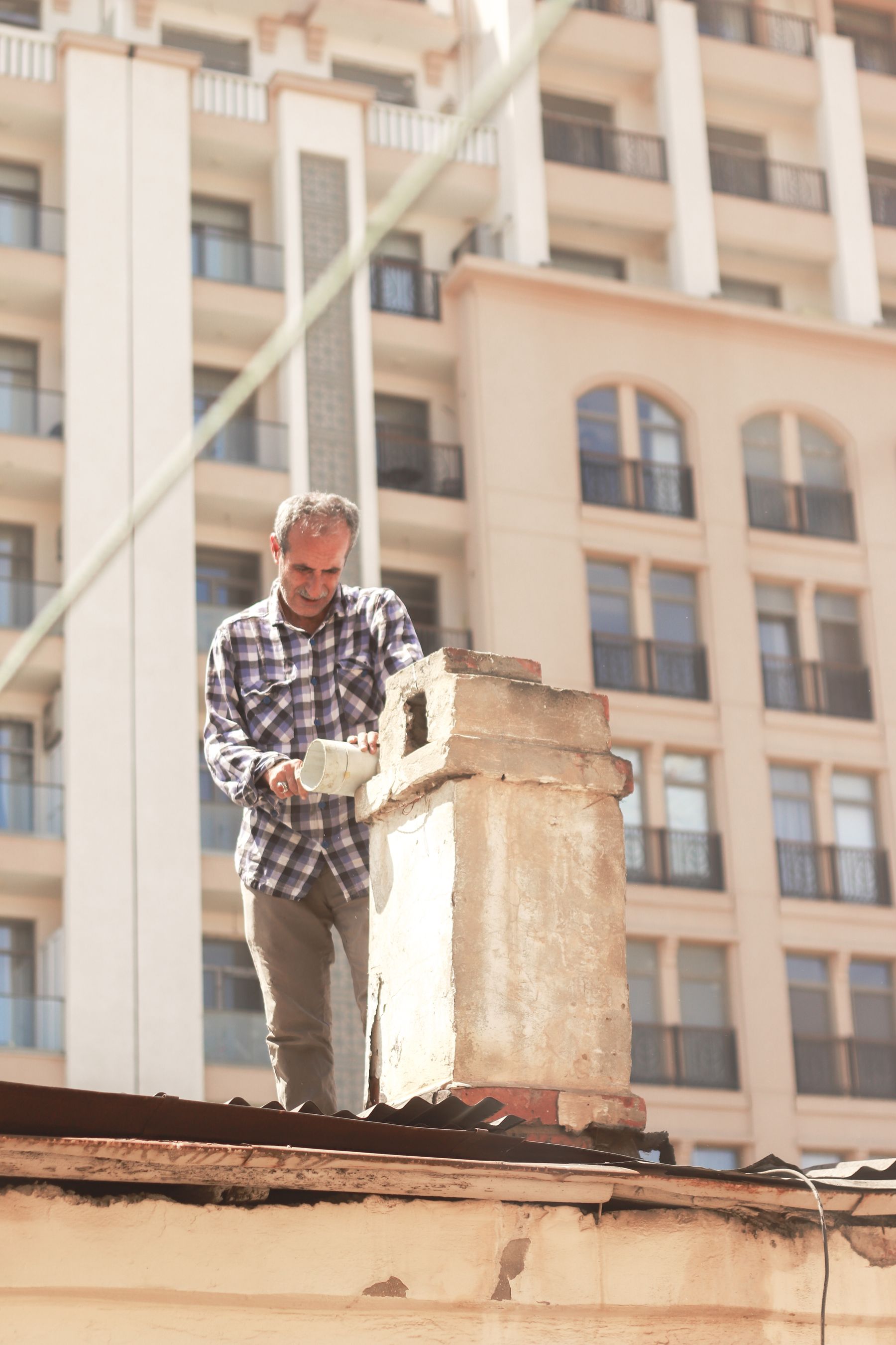 Chimney technicians inspecting a rooftop chimney in a wooded Oregon neighborhood