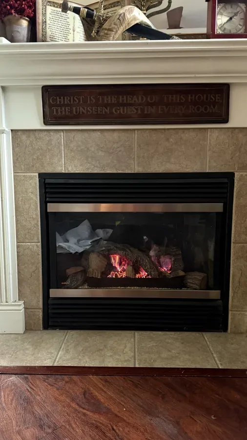 The same gas fireplace after cleaning, with clear glass and a clean flame