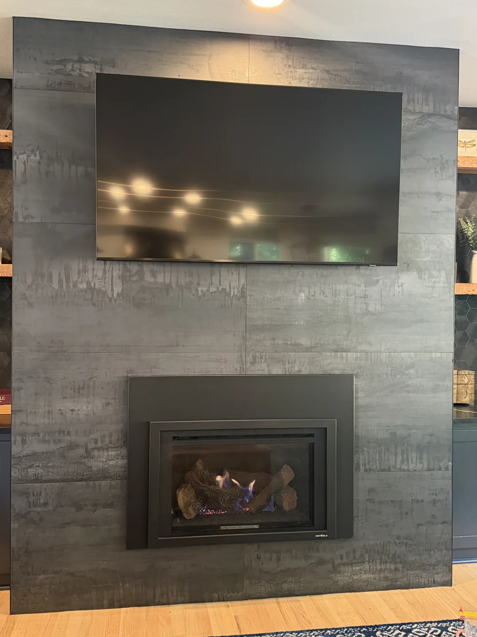 The same wall and the same opening after a gas fireplace insert was installed and lit